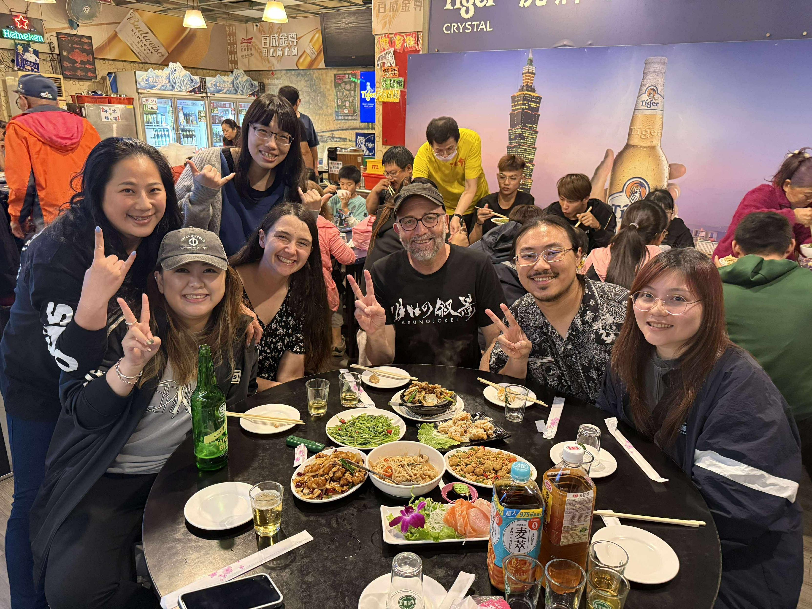 A group of people in a traditional Taiwanese stir-fry restaurant.
